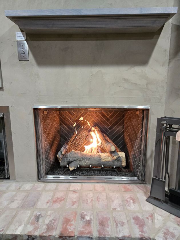 A fireplace with a log in it and a mantle.