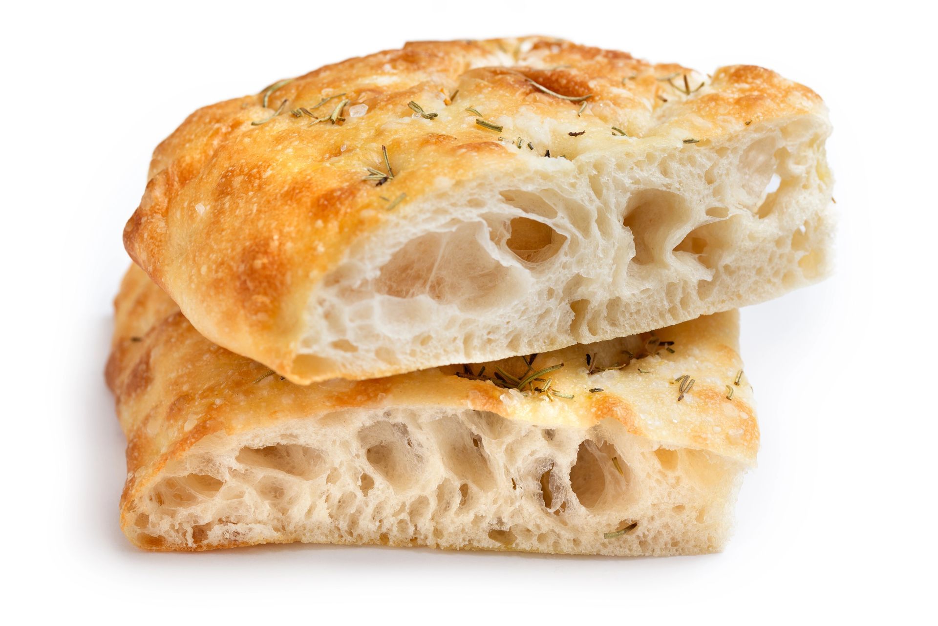 Due fette di focaccia, di colore marrone chiaro, interno arioso, erbe aromatiche visibili.