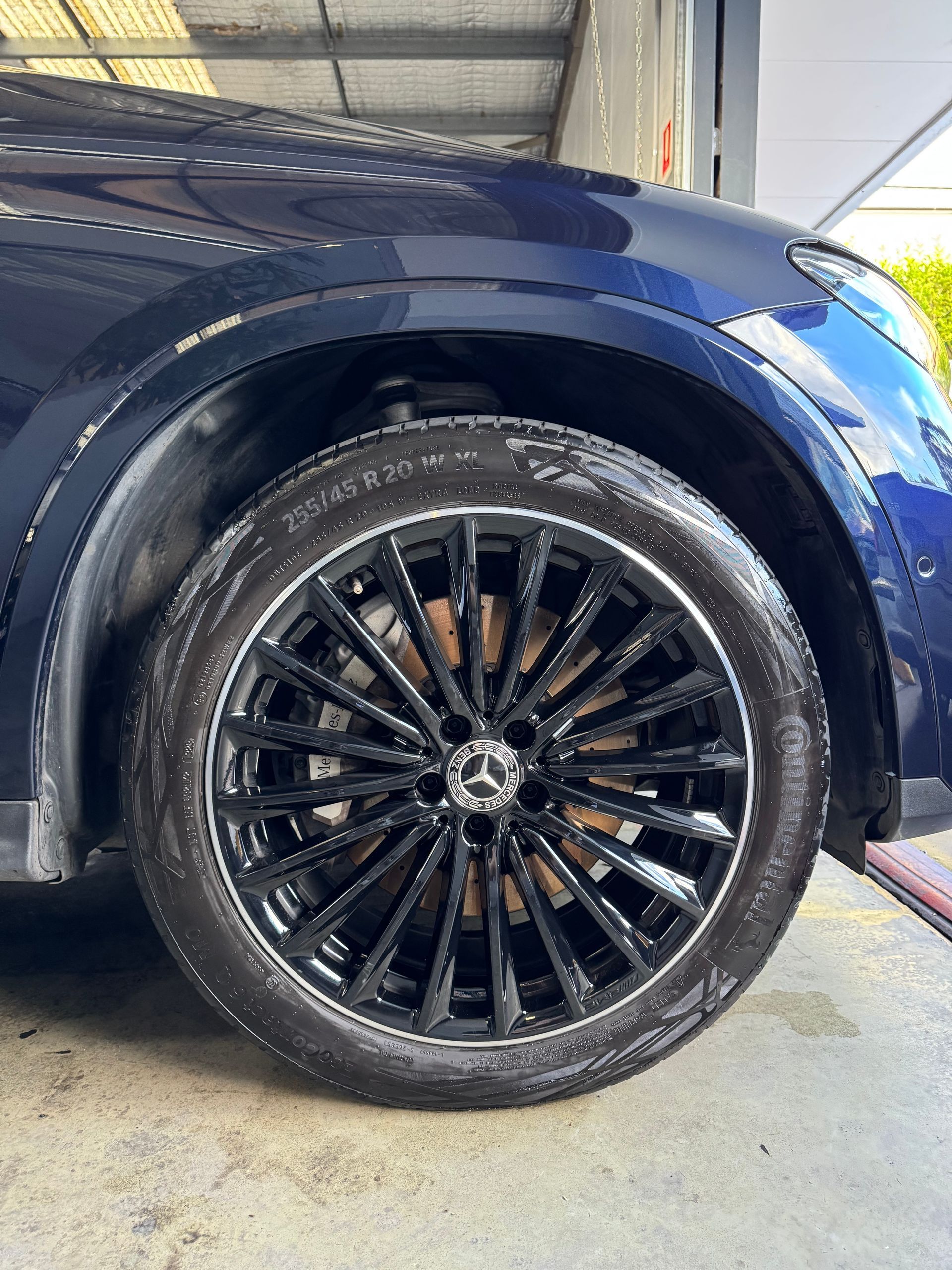 Black rim of a blue Mercedes-Benz car.