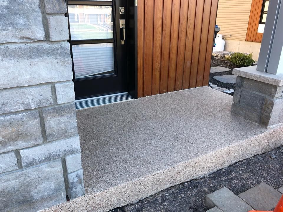 Une porte avec une passerelle en béton qui y mène et un mur de briques.