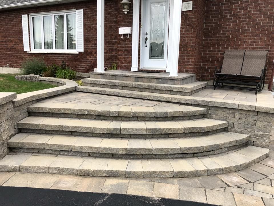 Un ensemble d'escaliers menant à la porte d'entrée d'une maison en briques.