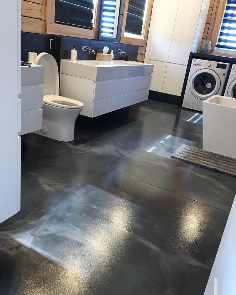 Une salle de bain avec toilettes, lavabo, laveuse et sécheuse.