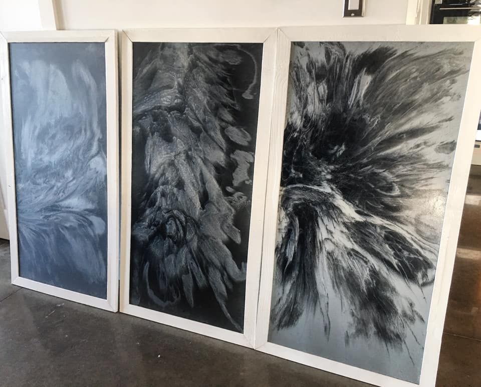 Trois tableaux en noir et blanc sont posés sur une table.