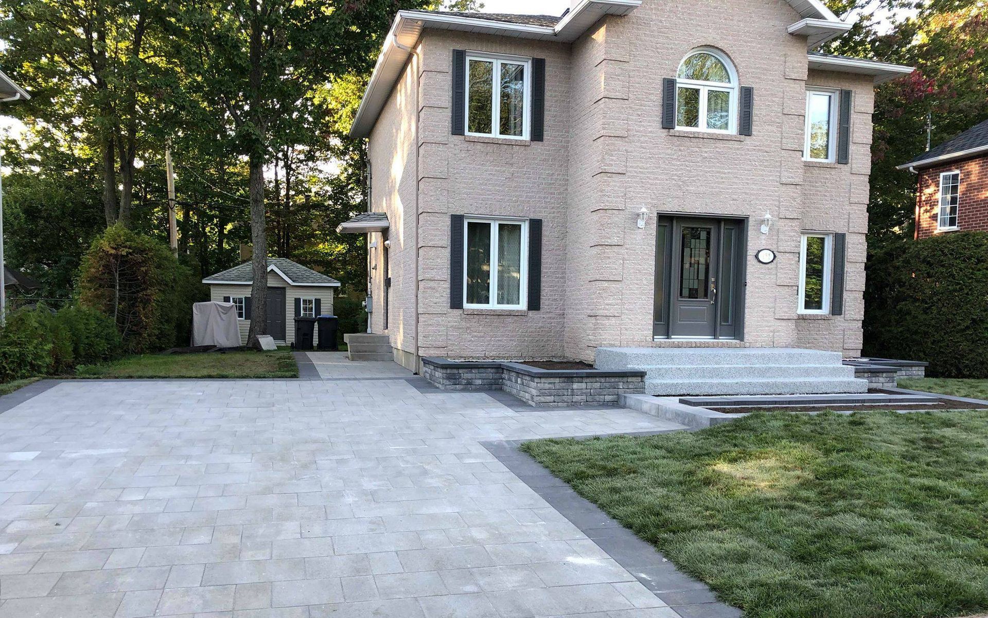 Une grande maison en brique avec une allée devant.