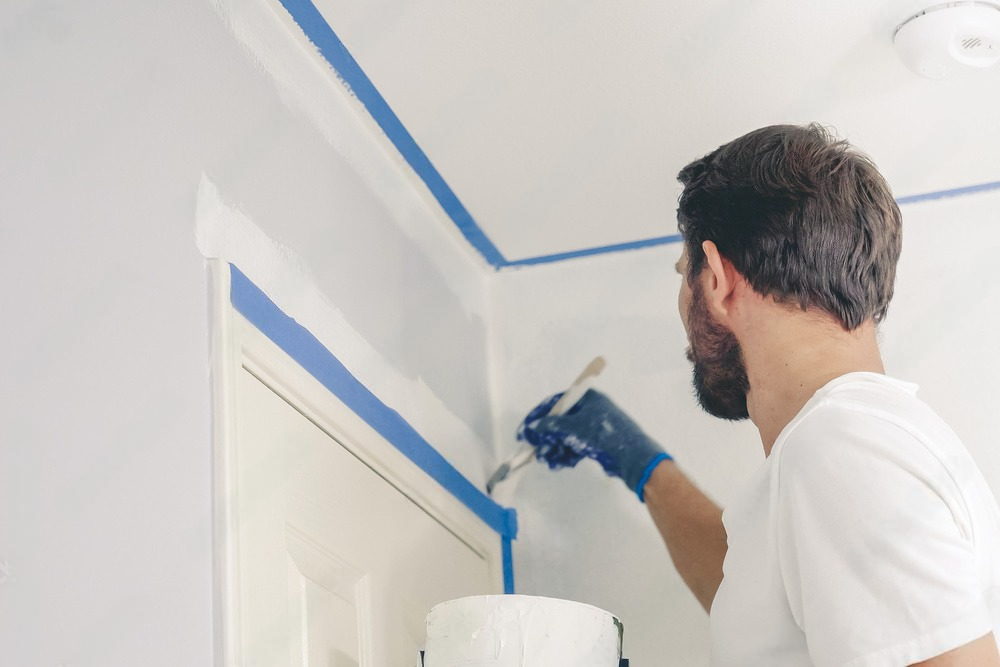 a man is painting a wall with a brush .