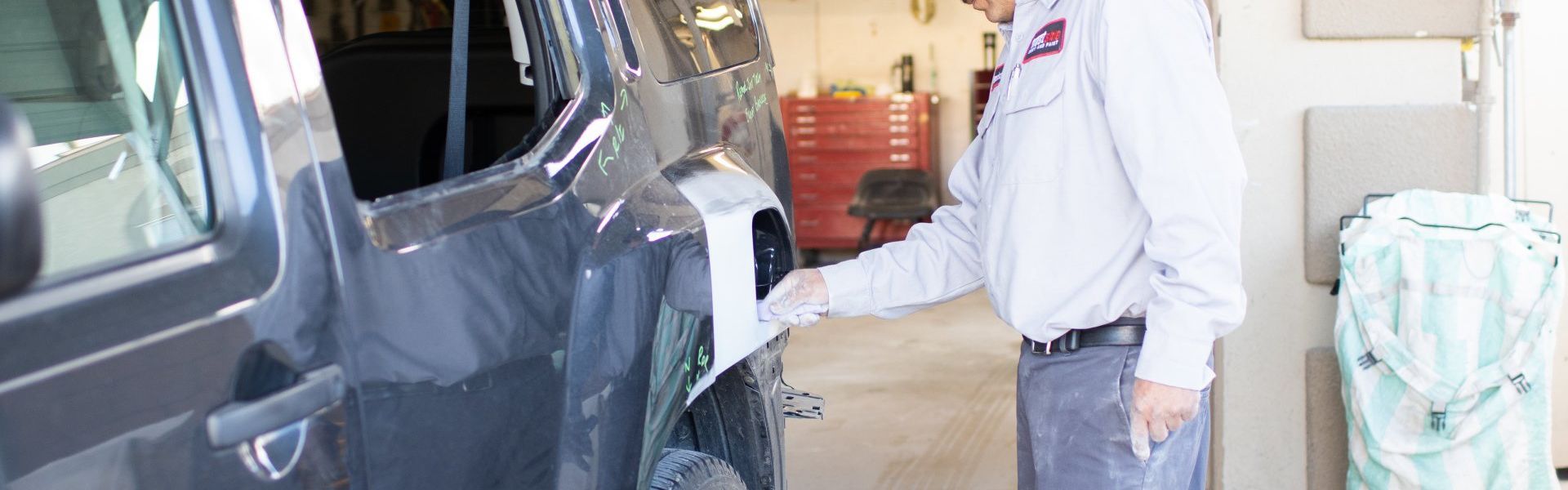 A person sanding the body of a car at Westside Body and Paint in Quartz Hill.