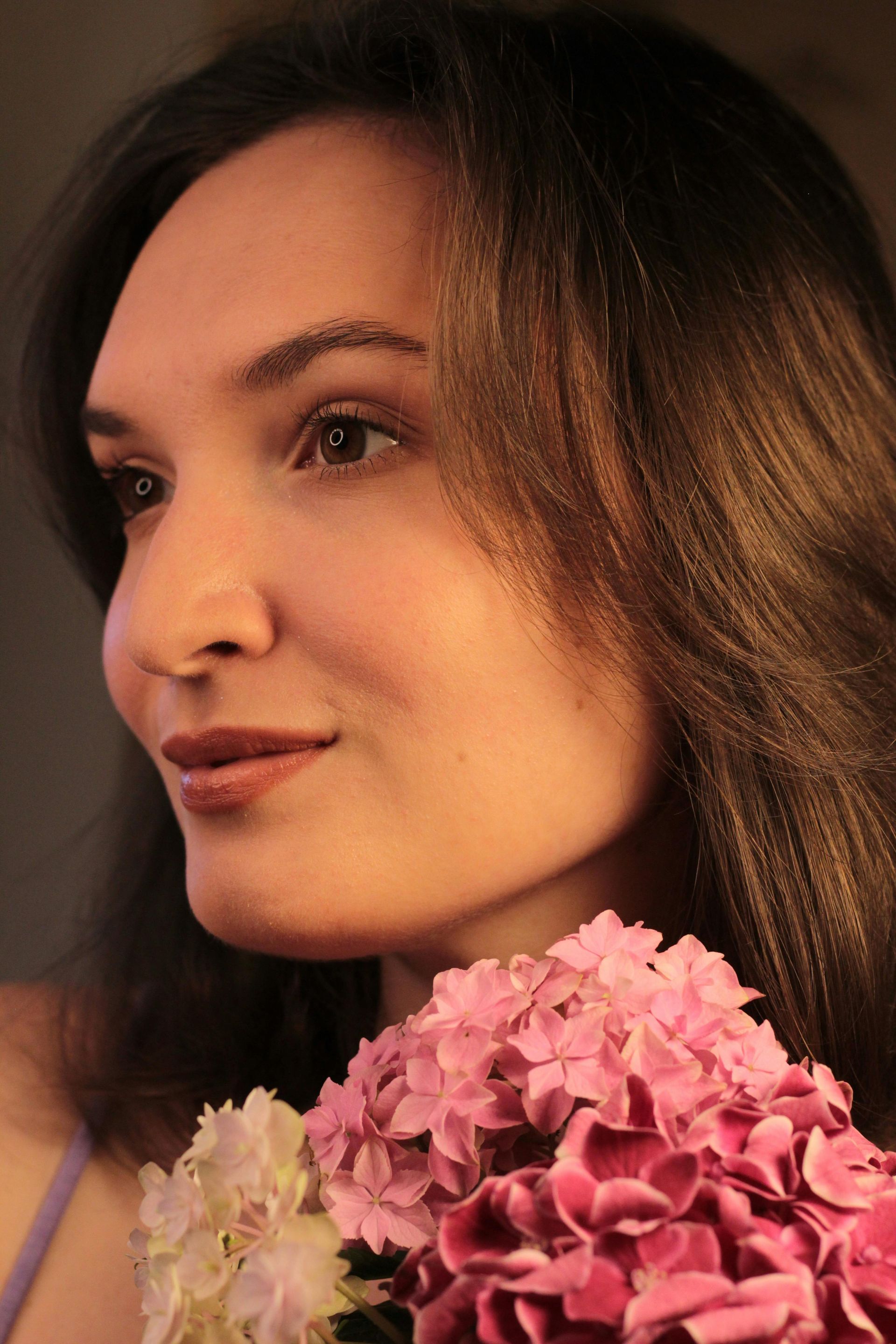 A woman is holding a bouquet of pink flowers.