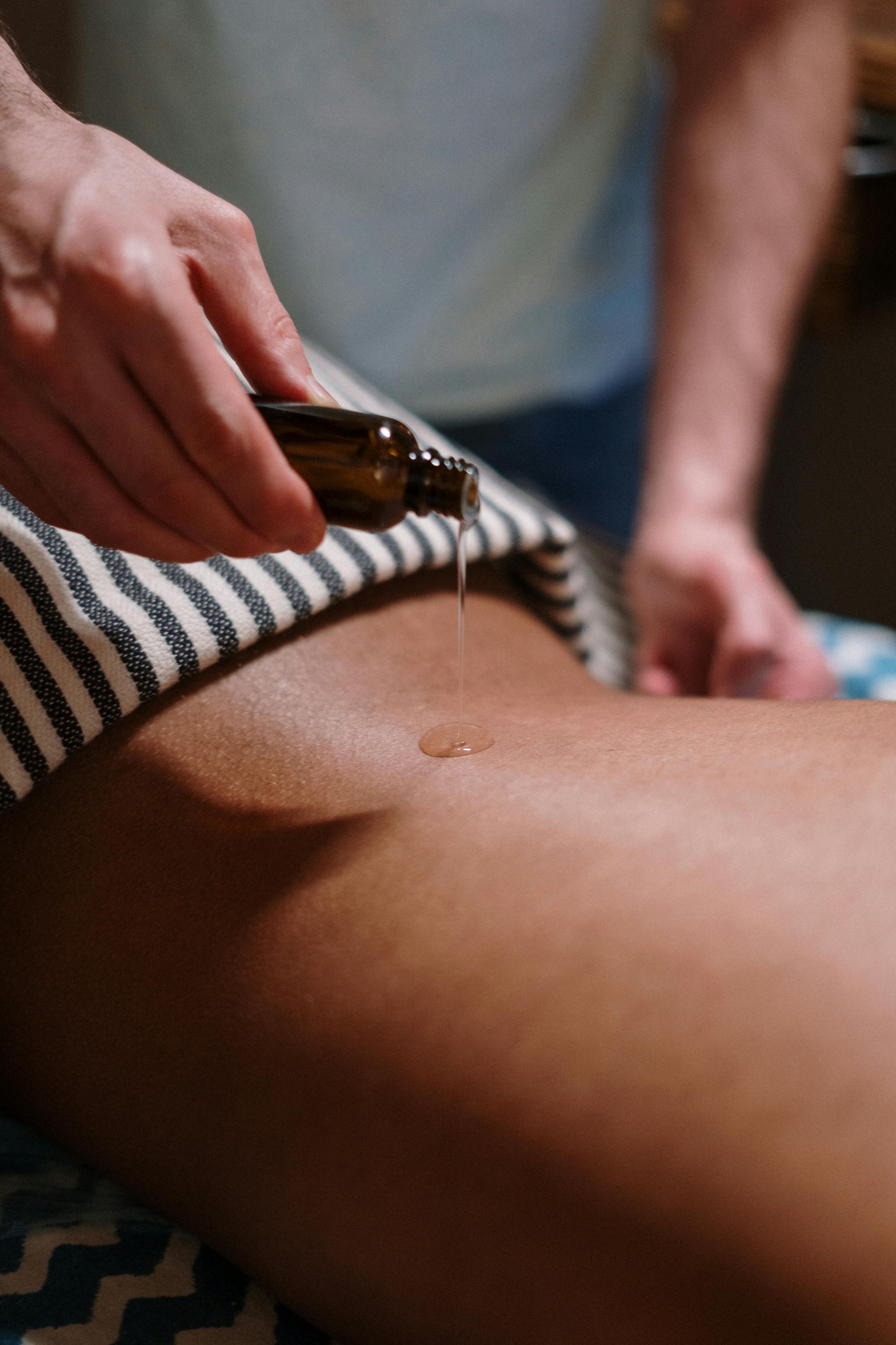 A person is getting a massage with oil on their back.