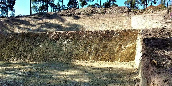 A large pile of dirt is sitting on top of a hill.