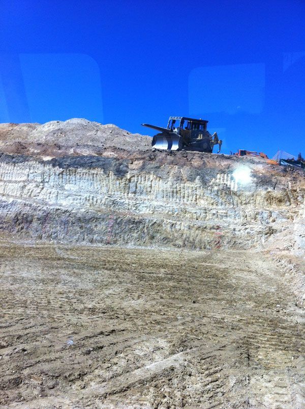 A bulldozer is sitting on top of a dirt hill.