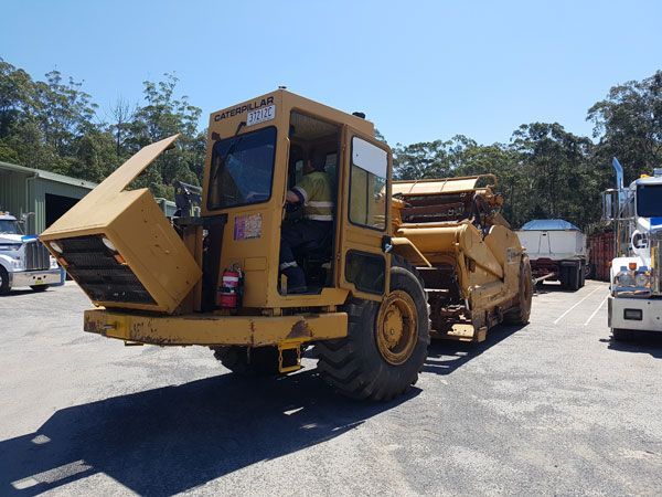 A yellow caterpillar truck is parked in a parking lot
