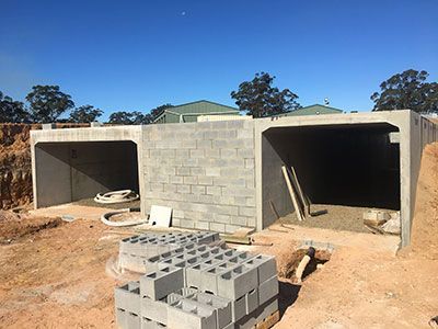 A stack of bricks is sitting in front of a building under construction.