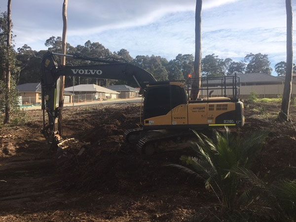 A volvo excavator is digging a hole in the dirt