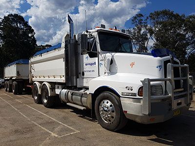 A white semi truck is parked in a parking lot.