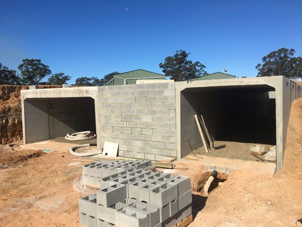 A stack of bricks sits in front of a building under construction