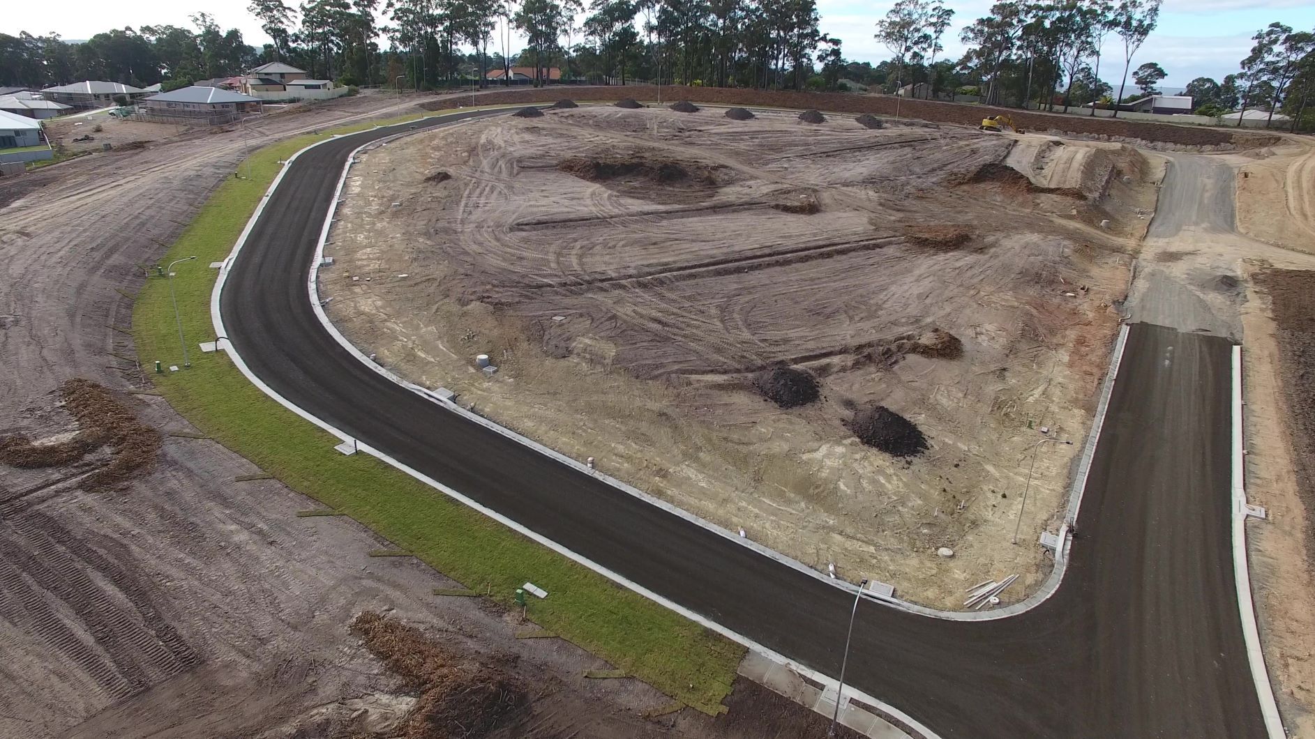 An aerial view of a road going through a dirt field