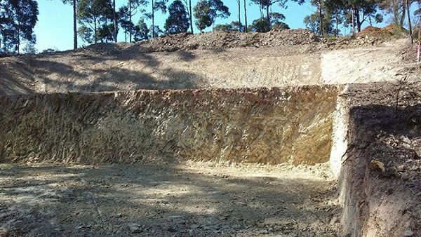 A large pile of dirt is sitting on top of a hill.