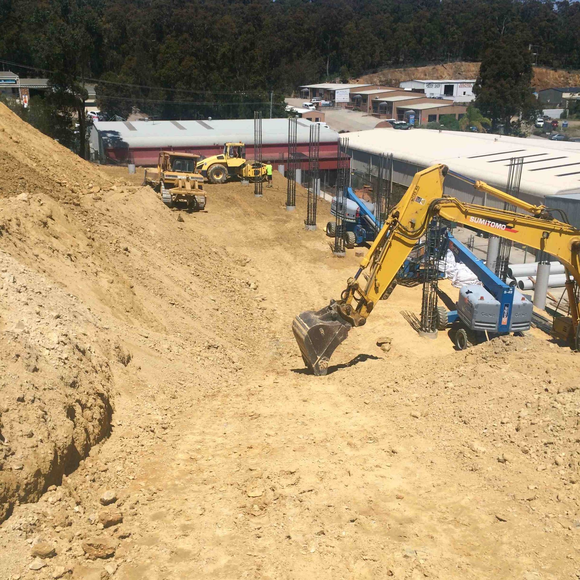 A yellow excavator is digging a hole in the dirt