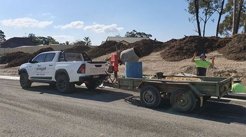 A truck is towing a trailer on a road.
