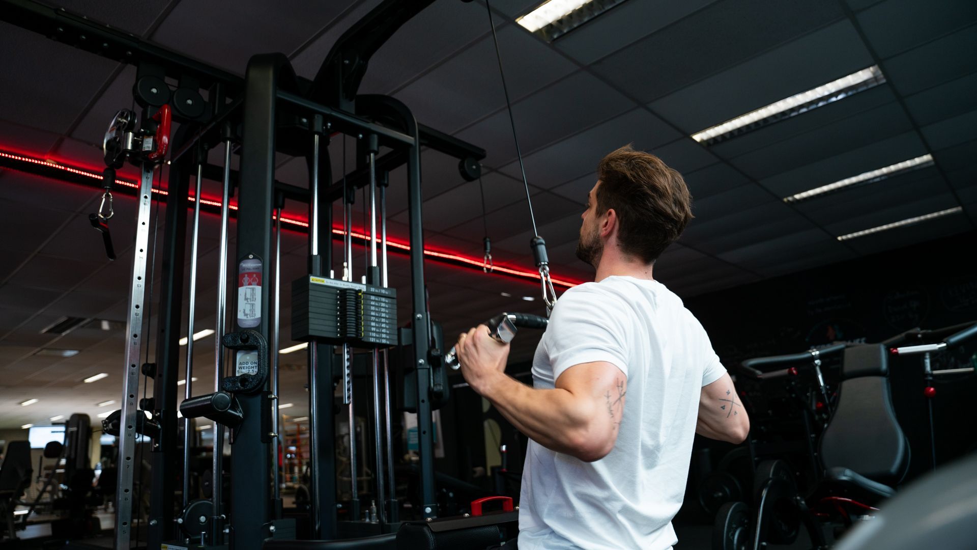 Een man gebruikt een machine in een sportschool.