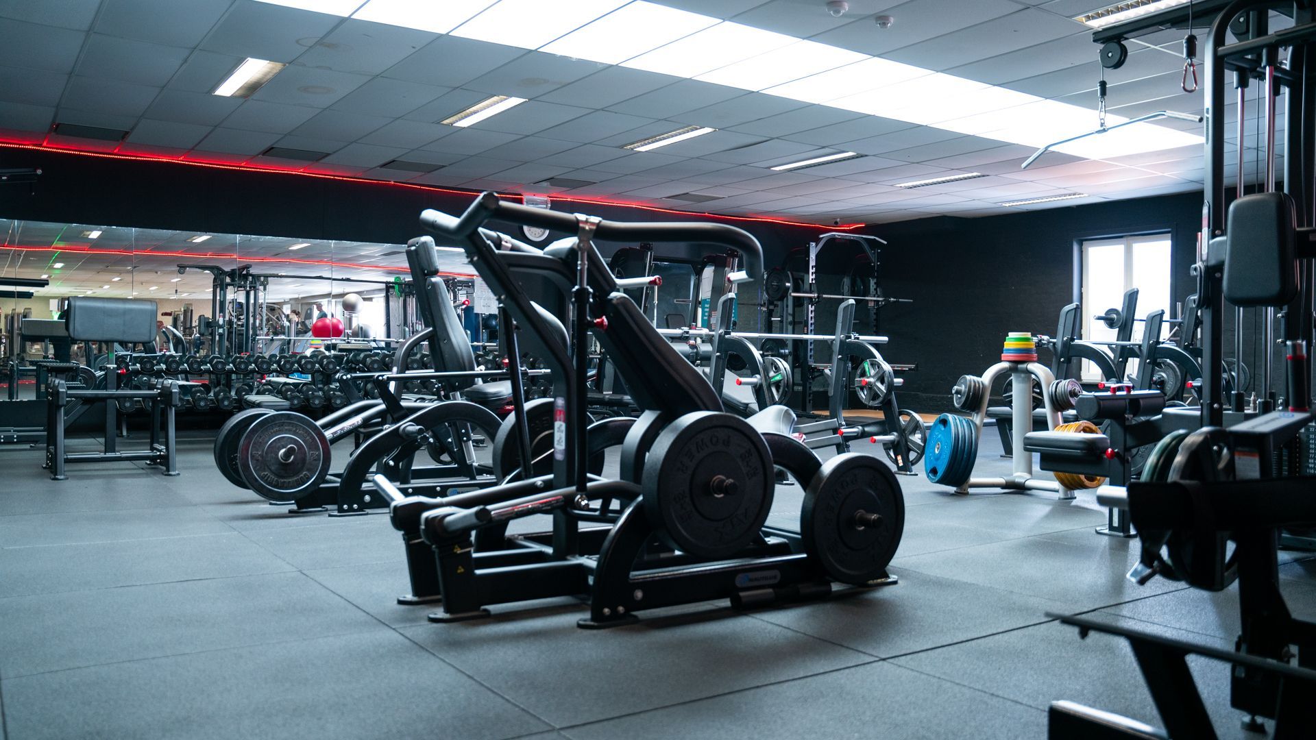 Een grote fitnessruimte vol met veel fitnessapparatuur.