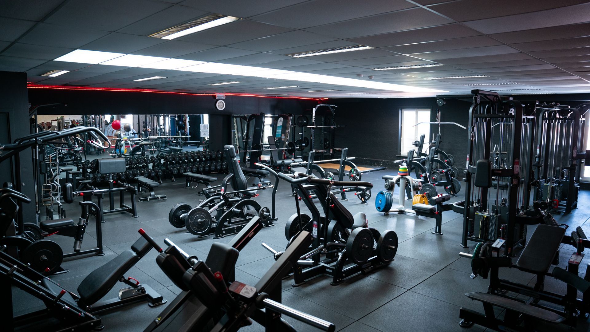 Een grote fitnessruimte vol met veel fitnessapparatuur.