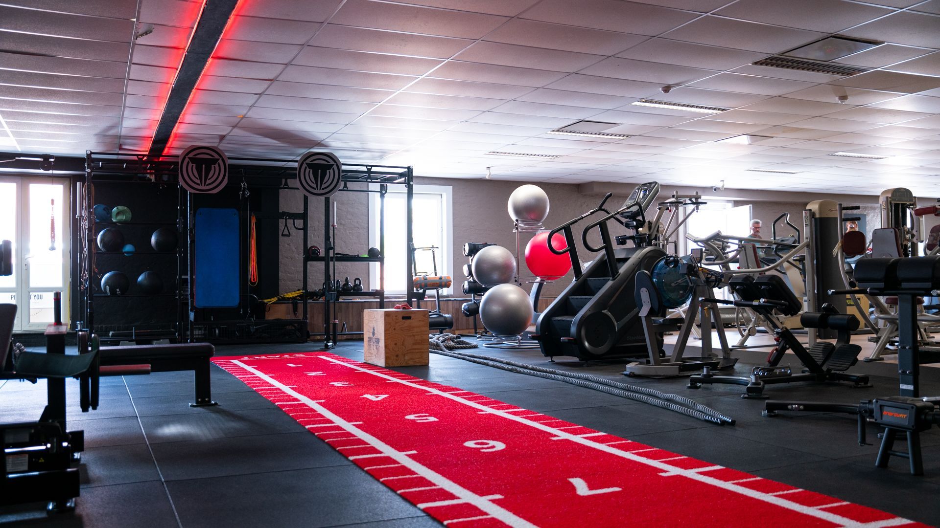Een grote sportschool met een rode baan en een bord met 'leeftijd' erop