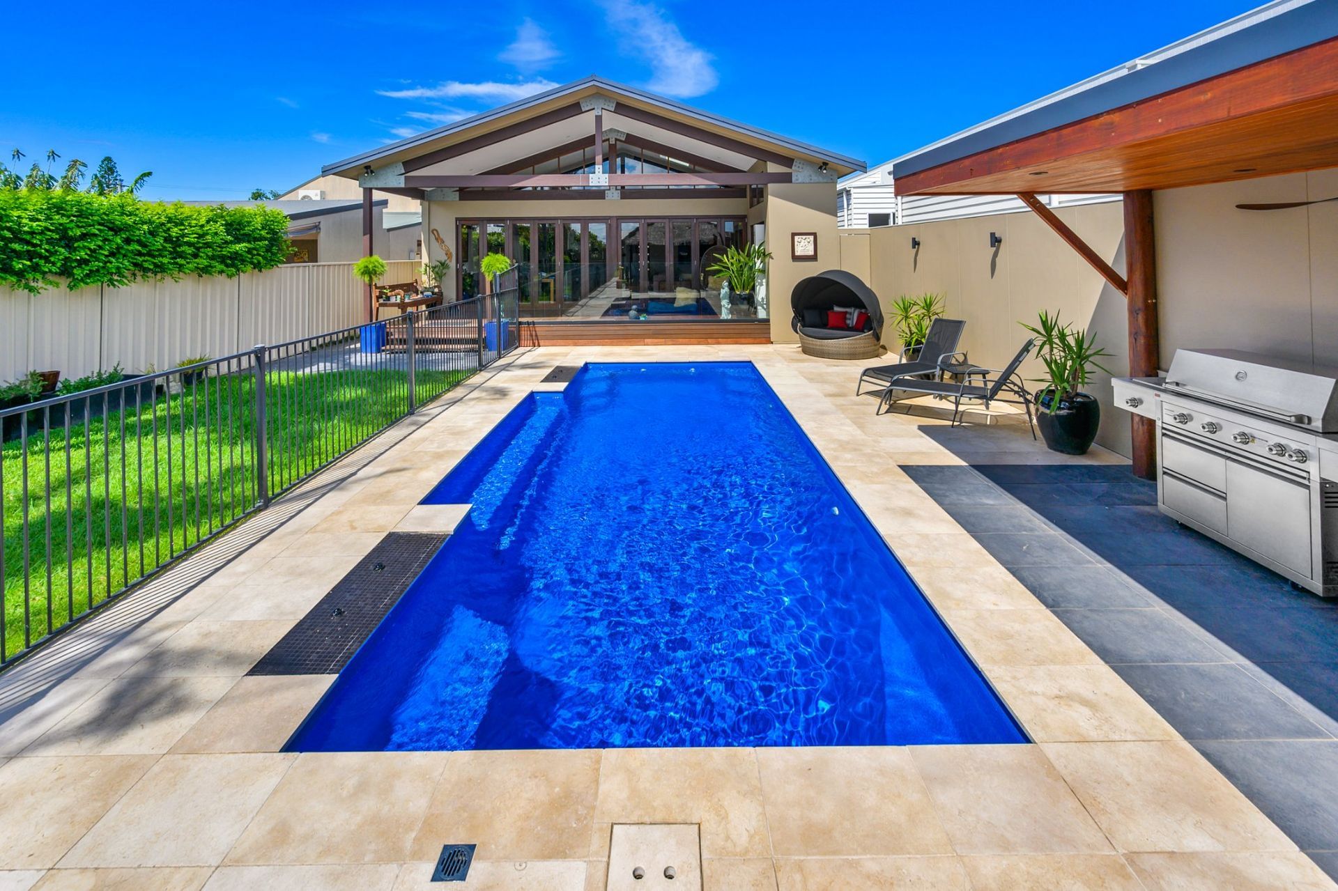 A Large Blue Swimming Pool In Front of A House — Swimming Pool in Scone, NSW