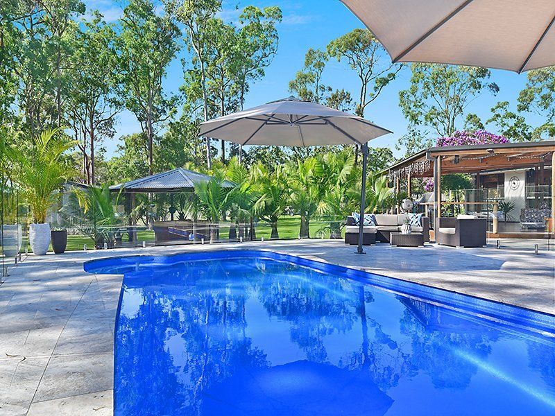 A Large Swimming Pool With Lounge Chairs Around It — Swimming Pool in Lake Macquarie, NSW