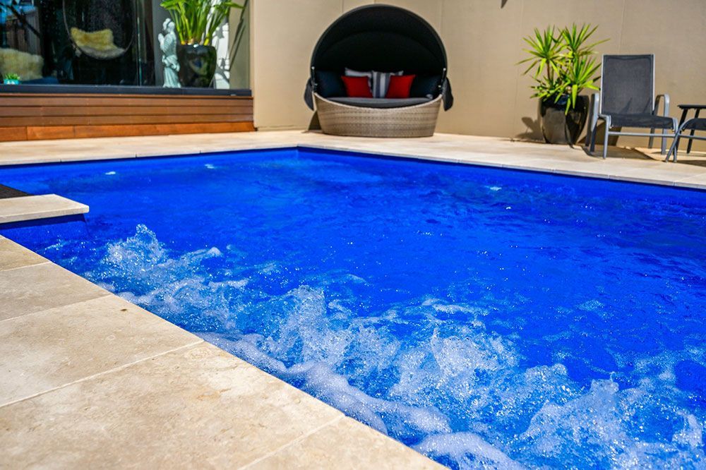 A Large Swimming Pool With A Day Bed In The Background — Mineral Pool in Newcastle, NSW