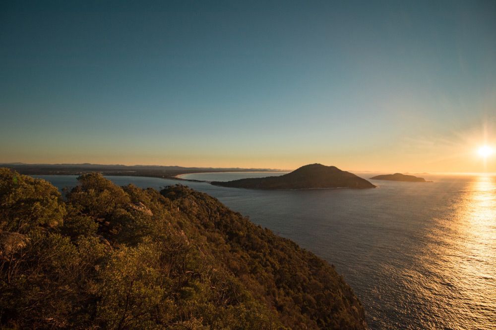 A Sunset Over A Body Of Water With Mountains In The Background — Automatic Pool Cleaner in Port Stephens, NSW