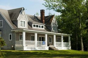 A large house with a large porch and a chimney