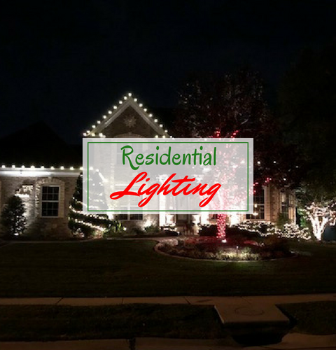 Residential Lighting sign lit at night in front of a decorated house