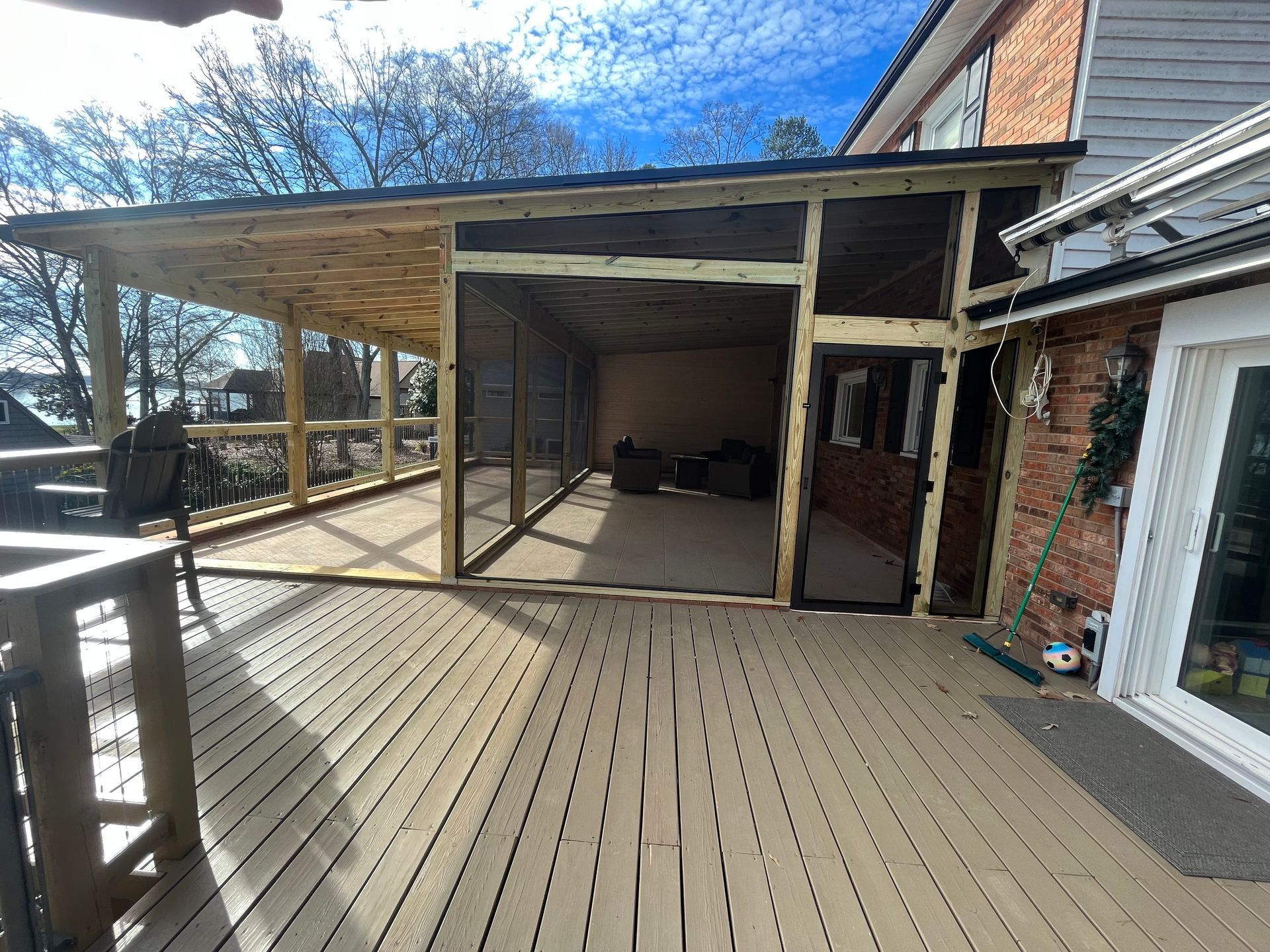 Wooden deck with a covered patio and pergola attached to a brick house