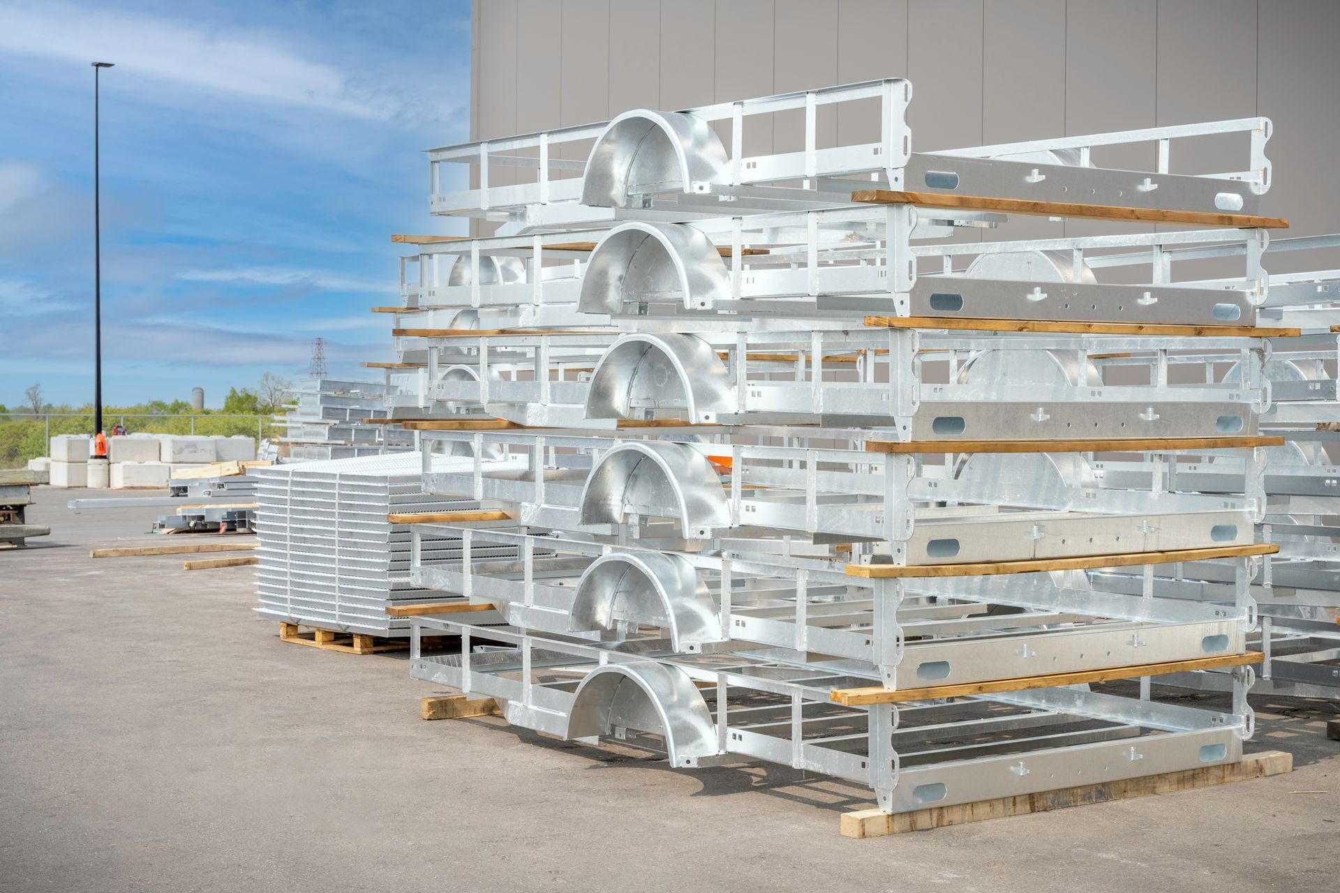 Stacked metal truck bed frames on pallets outdoors.