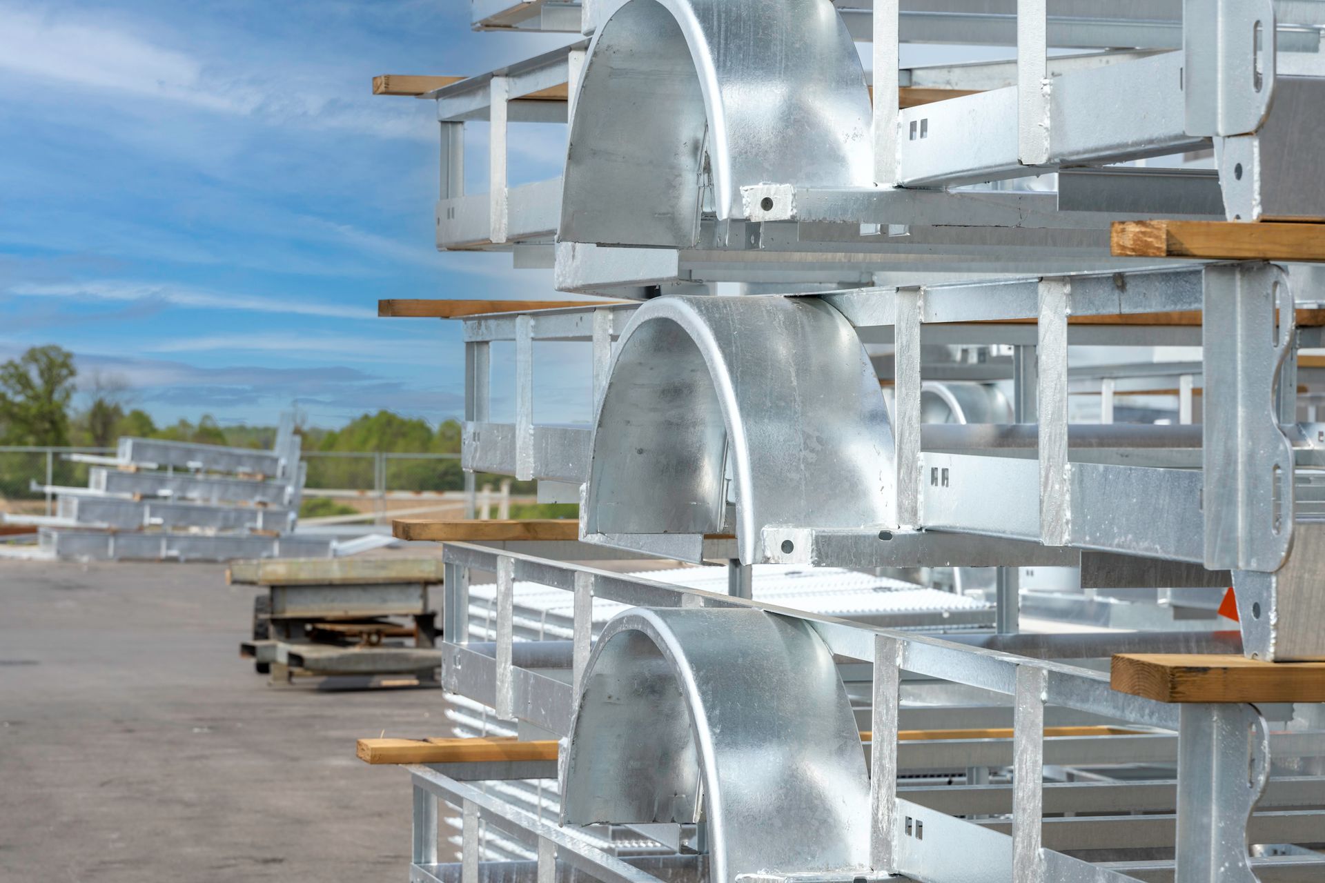 Metal trailer parts stacked outdoors.