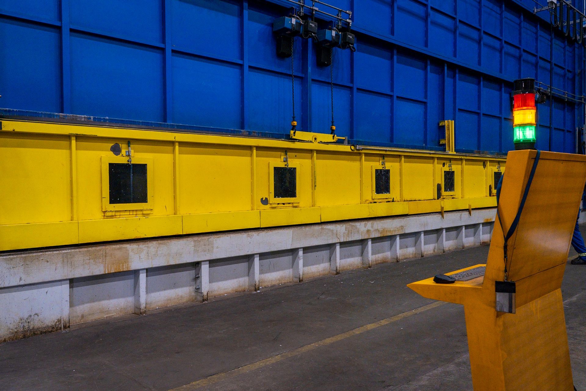 Yellow and blue industrial scene with a control panel and traffic light.