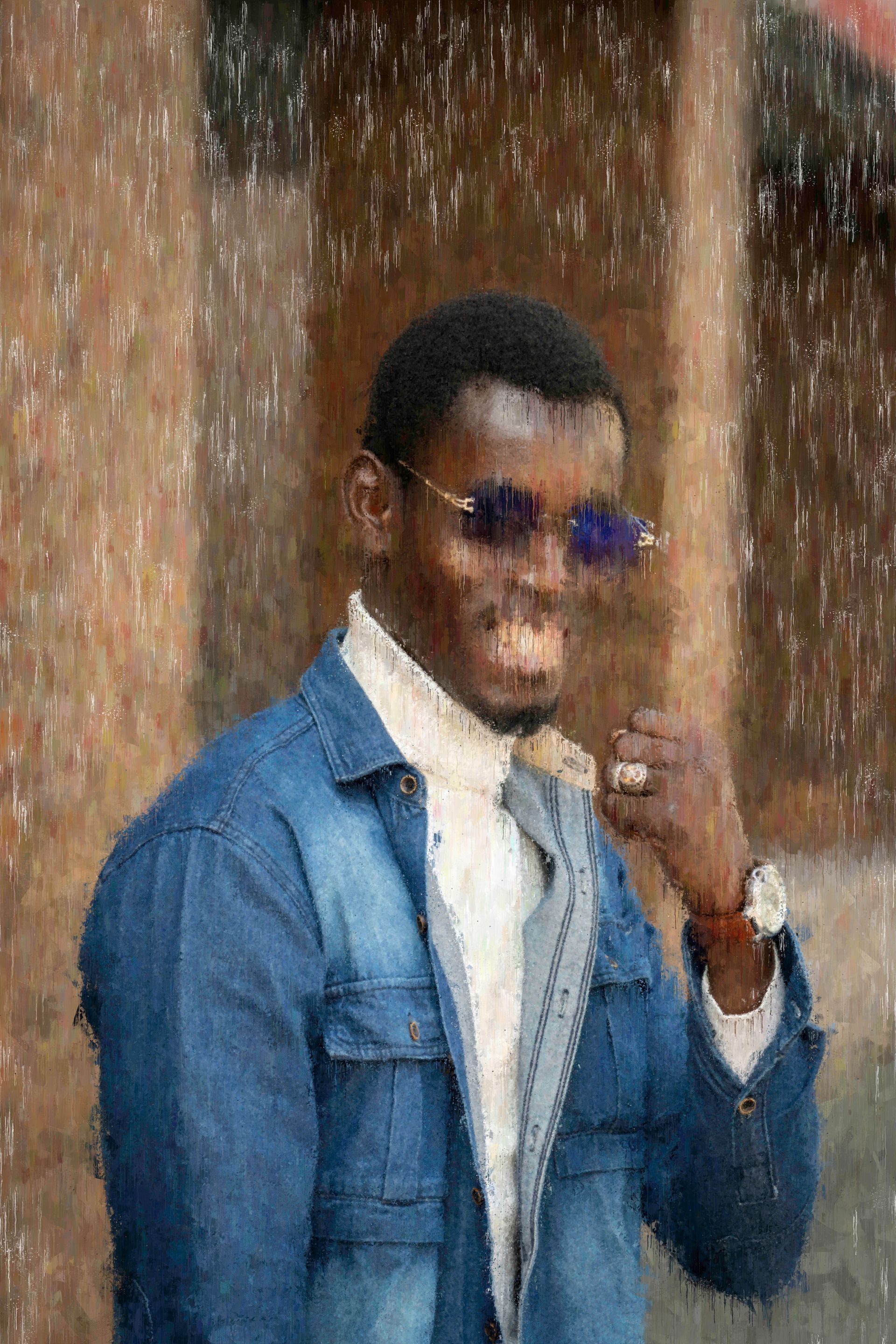 Man in denim jacket and sunglasses, holding his hand near his mouth, standing outside.