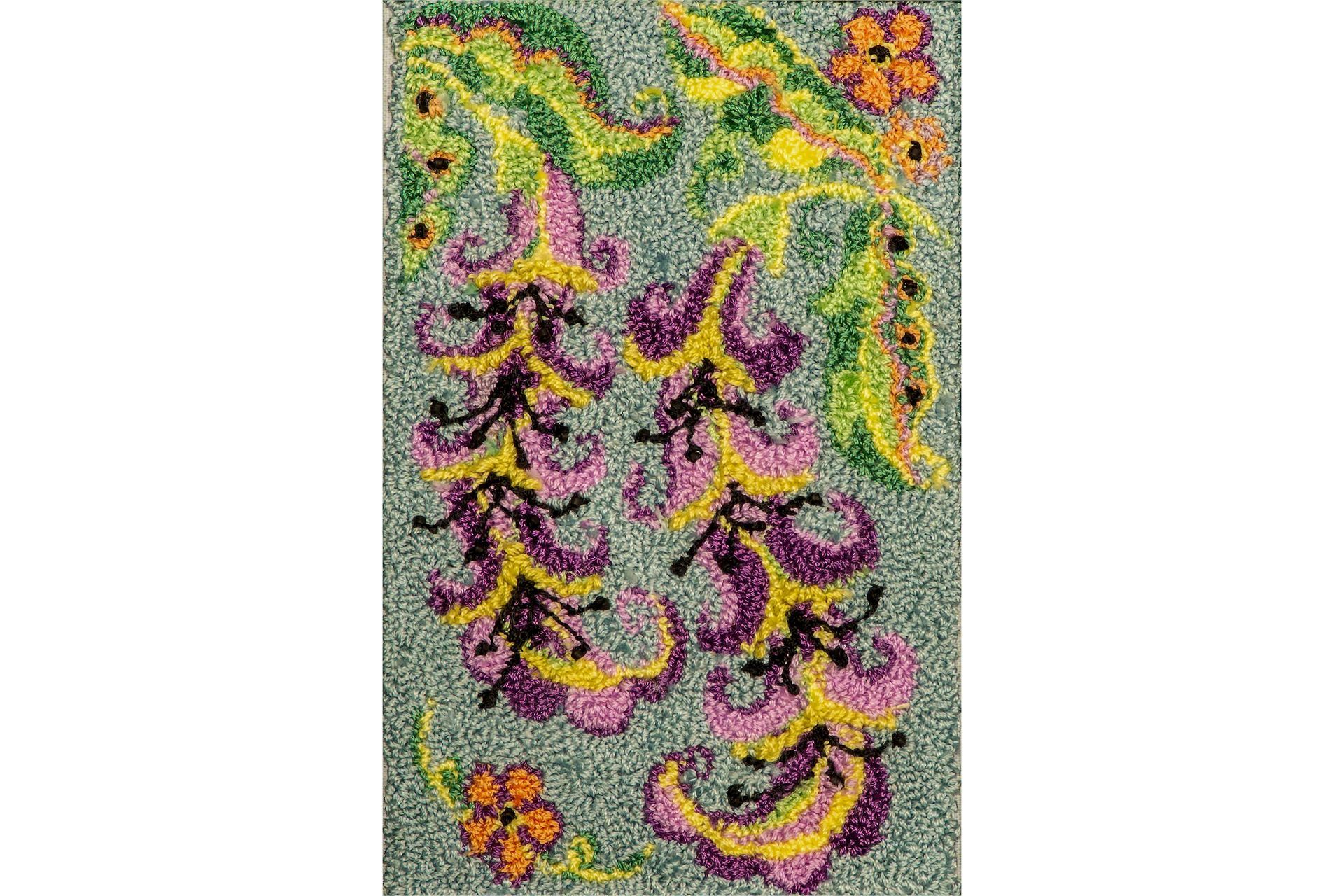 Floral rug with purple, yellow, and orange flowers on a green background.