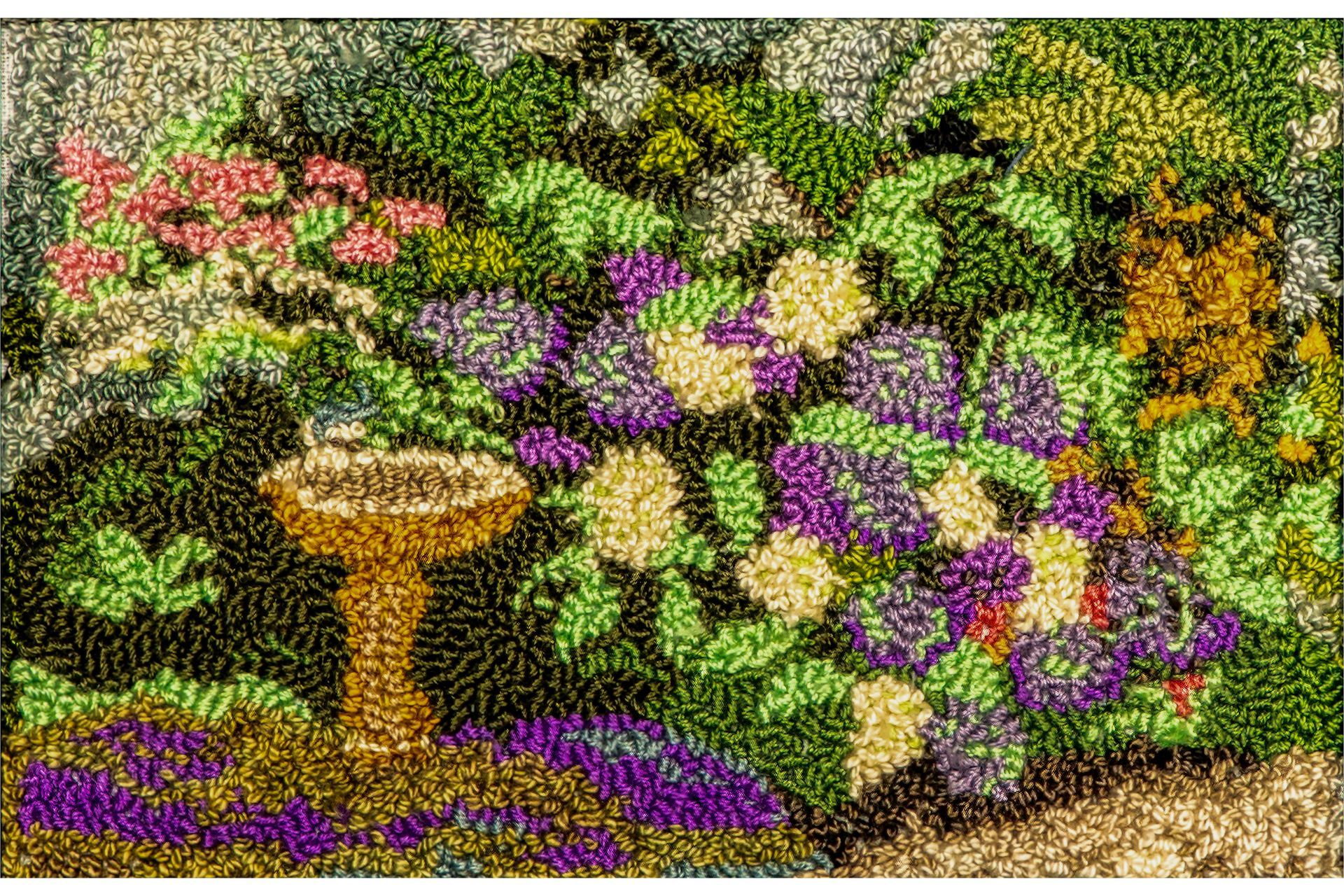 Beaded floral garden with birdbath. Purple, pink, cream, green beads on dark ground.