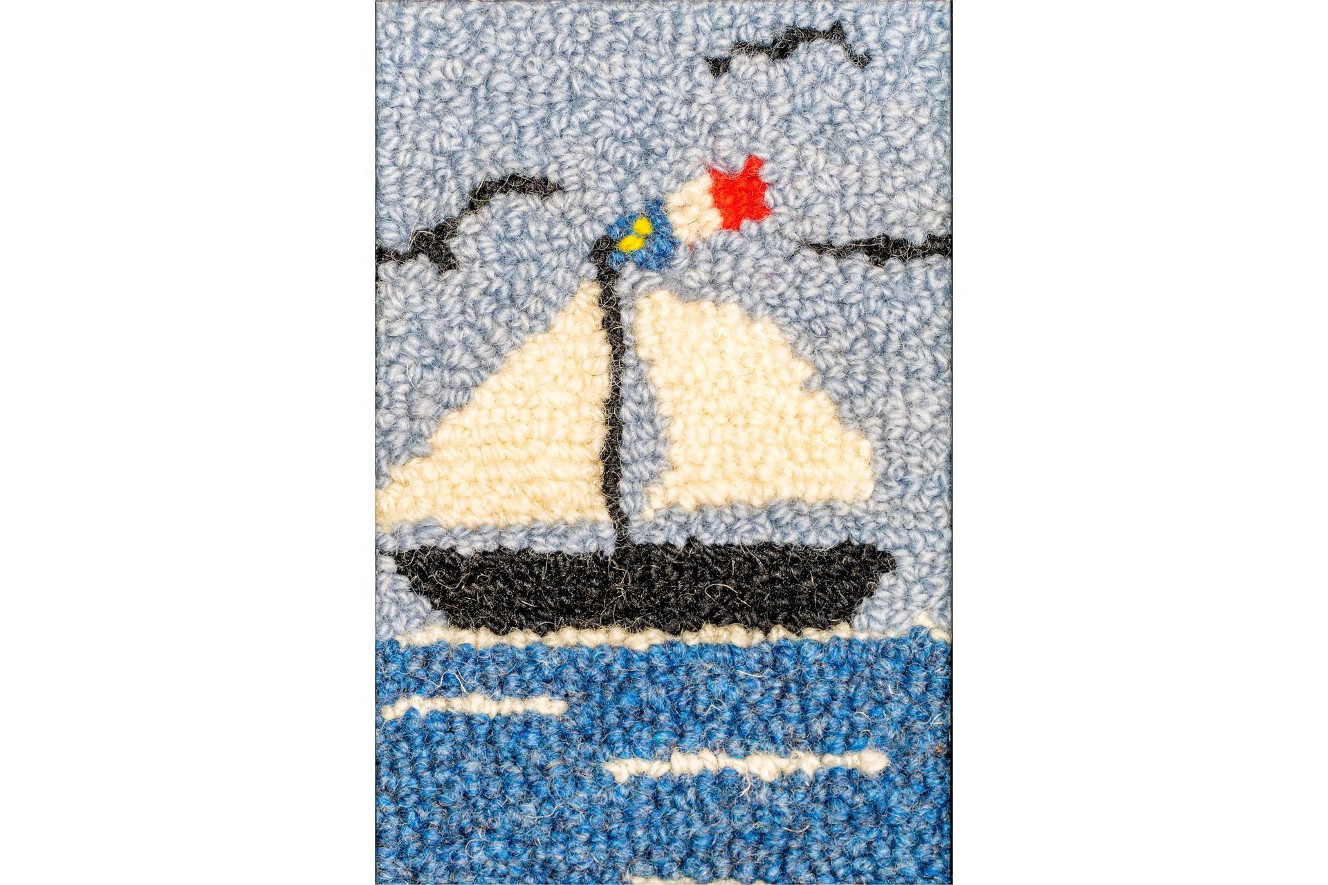 Sailboat on blue water with white sails, dark hull, and flag, under a blue sky.