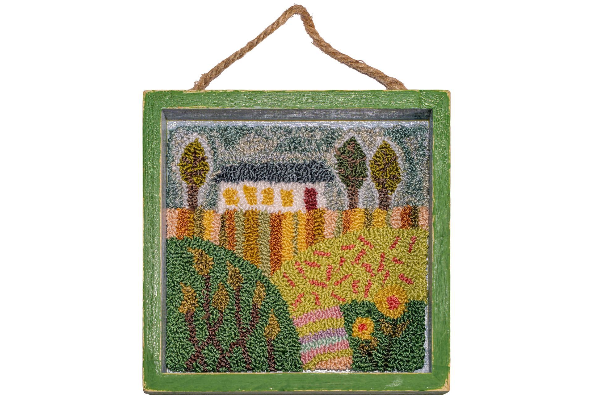 Beaded art of a house and yard scene, framed in green with a rope hanger.