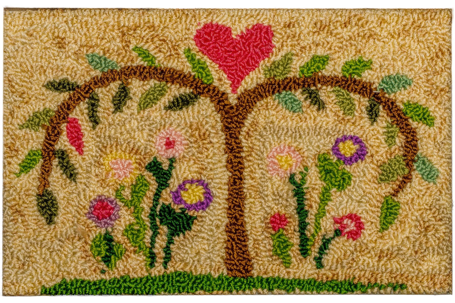 Beige rug with a tree shape, a red heart, colorful flowers, and green leaves.