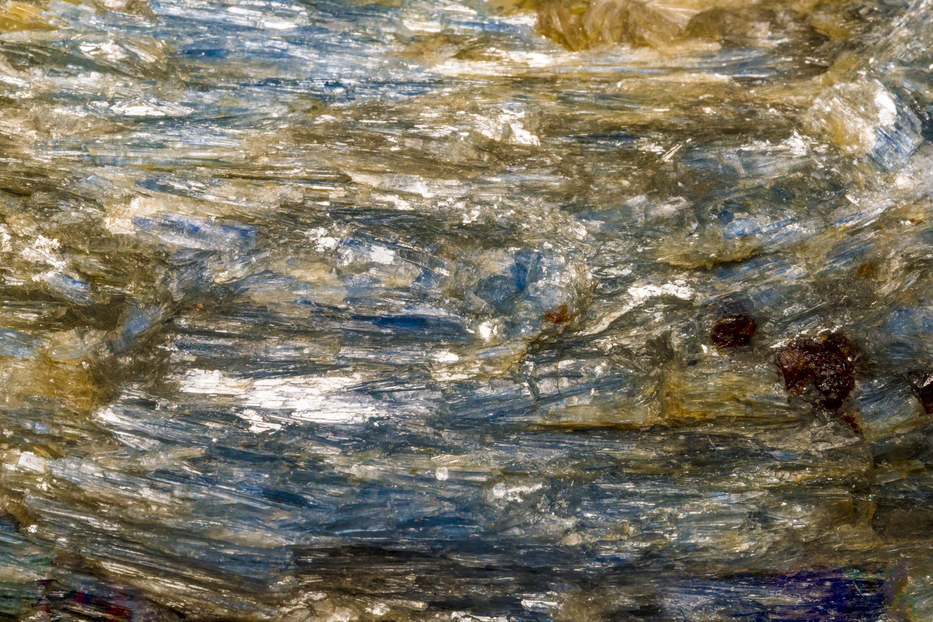 Close-up of a blue and gold layered rock, possibly a mineral, with a shiny, reflective surface.