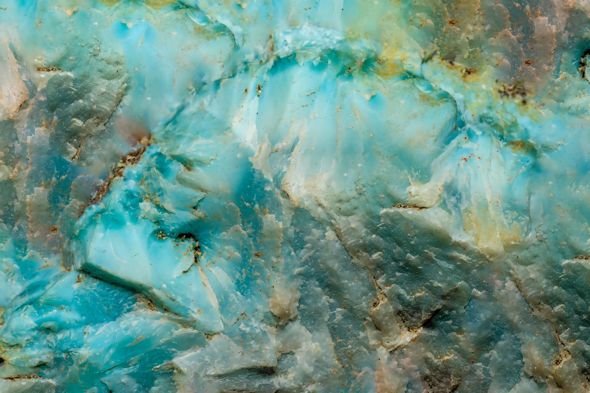 Close-up of a stone, showing rough, textured surface with shades of blue, turquoise, and tan.