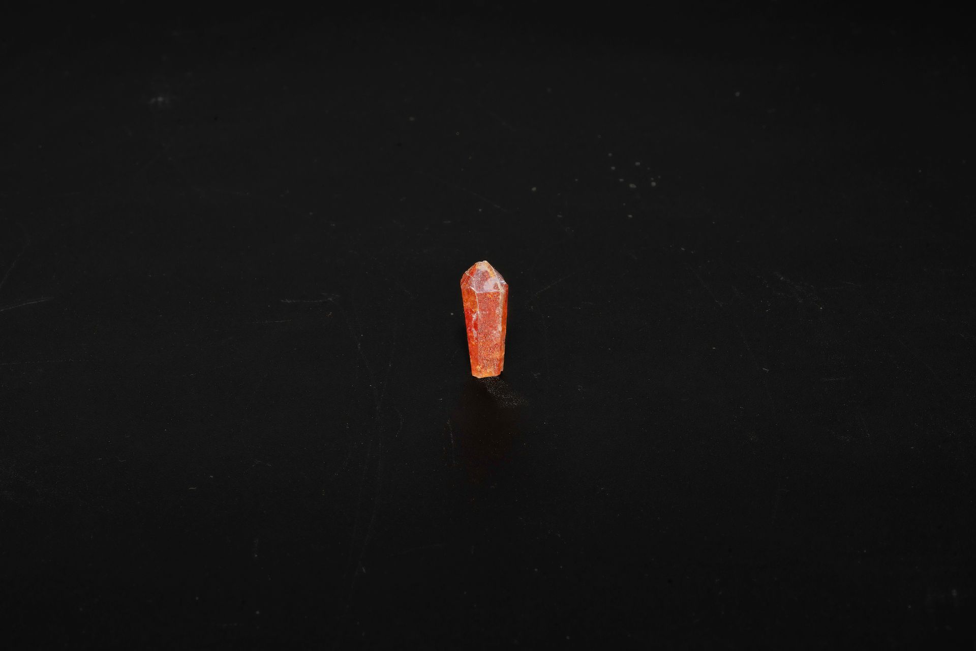 Orange, crystal-like mineral on a black background.