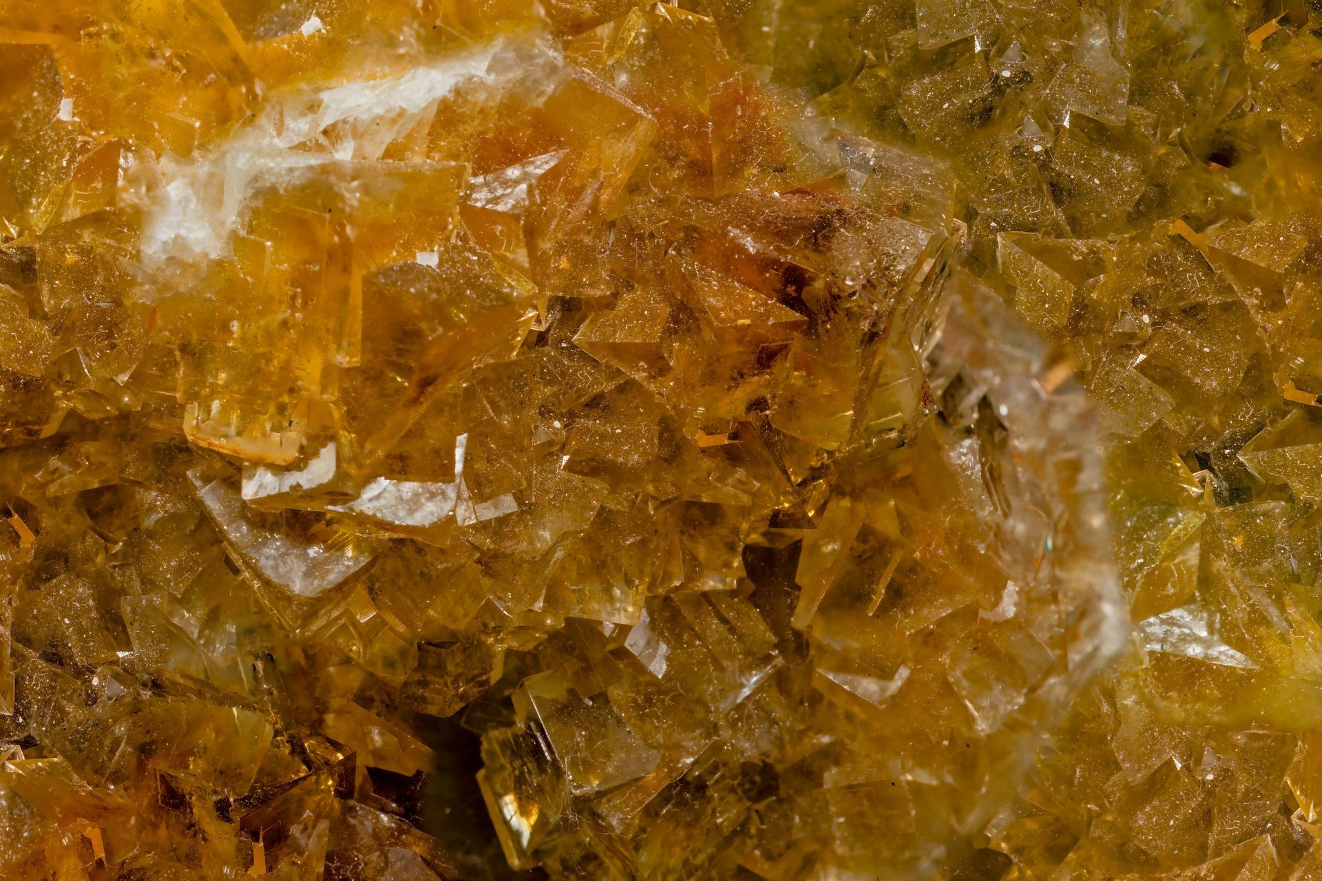 Close-up of a mineral formation with layered, translucent, yellow-brown, and white crystalline structures.
