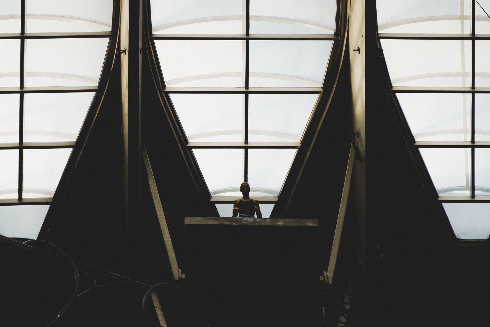 Person silhouetted in front of a window, standing at a dark counter.