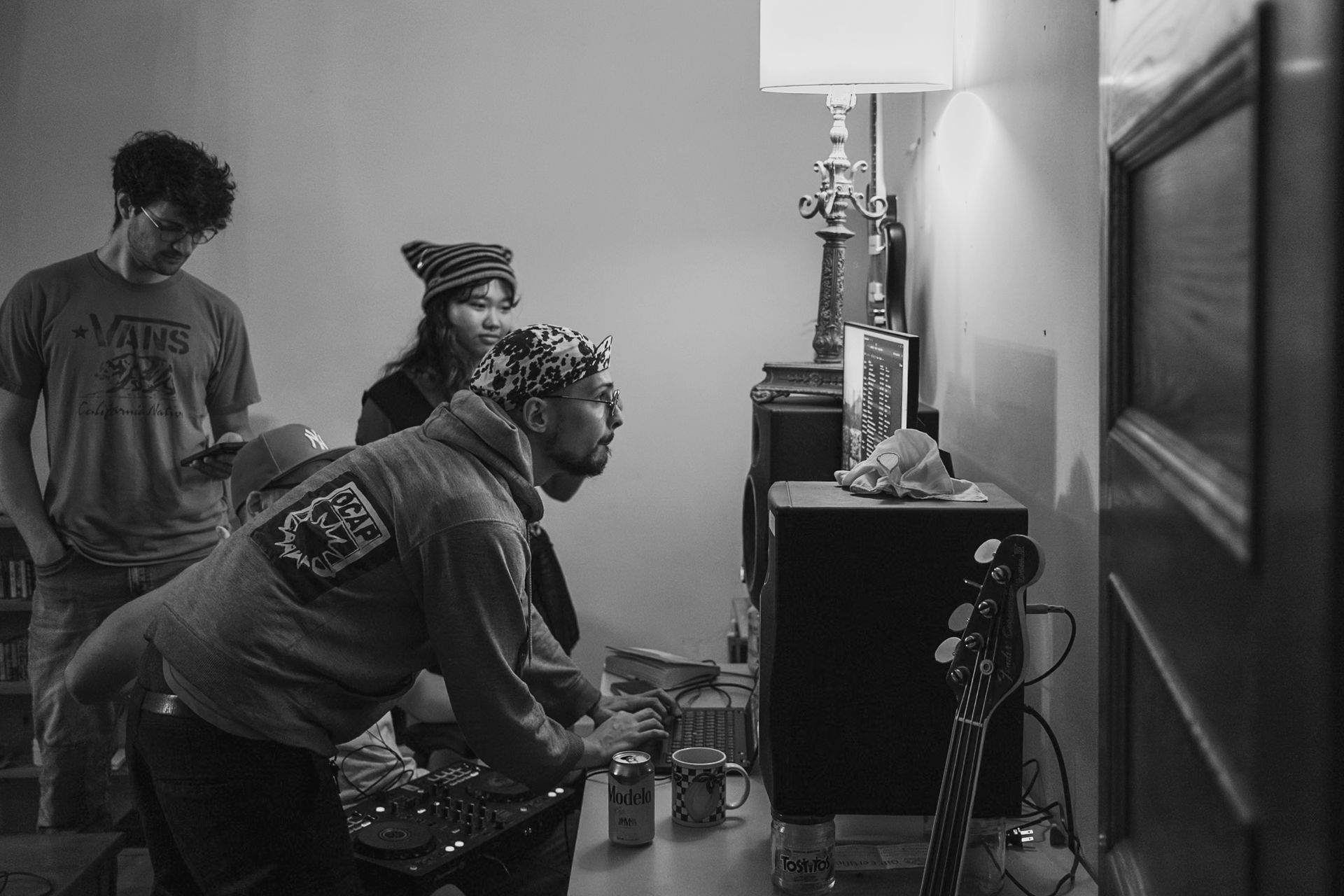 Three people looking at an object on a table, possibly a screen, in a room.