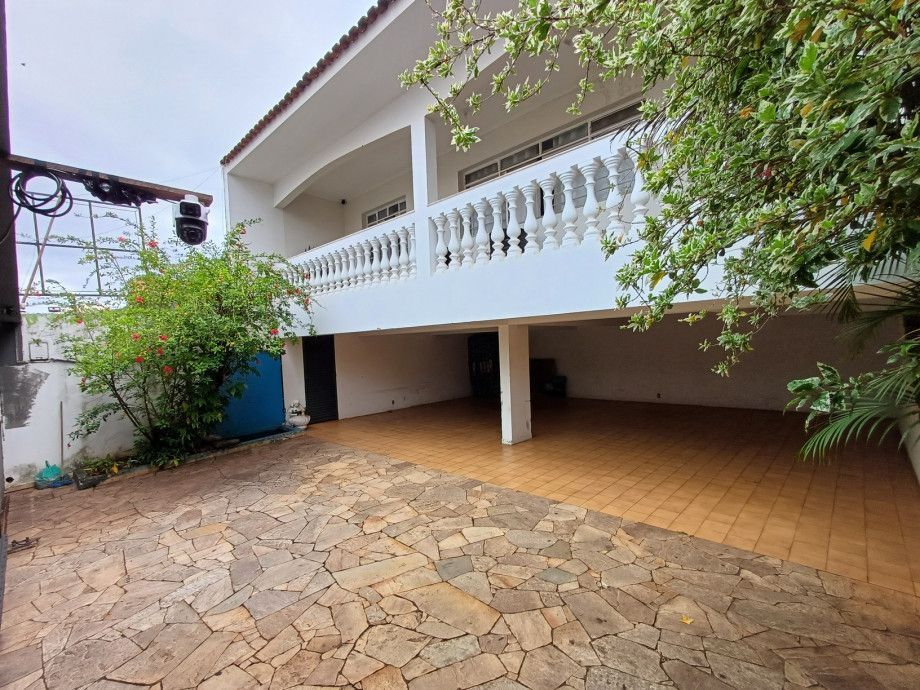 Uma grande casa branca com uma entrada de pedra na frente.